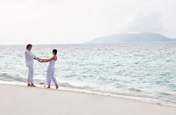 Foto van romantische jong koppel met een voet op de zee sho — Stockfoto