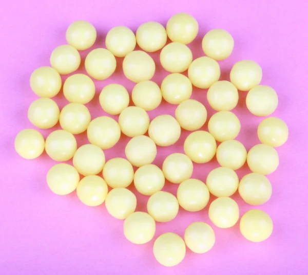 Vitaminas amarelas em fundo rosa — Fotografia de Stock