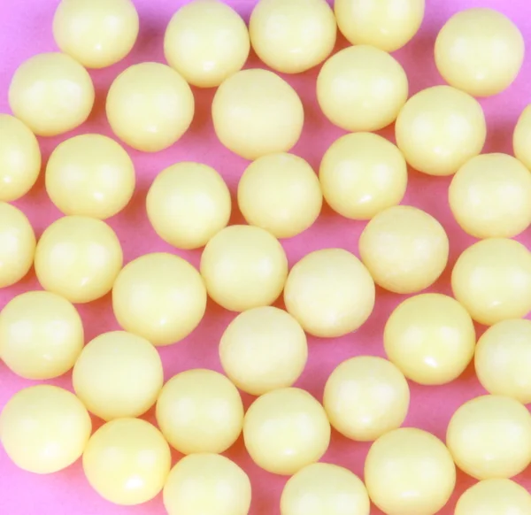 Žlutá vitamíny na růžovém pozadí — Stock fotografie
