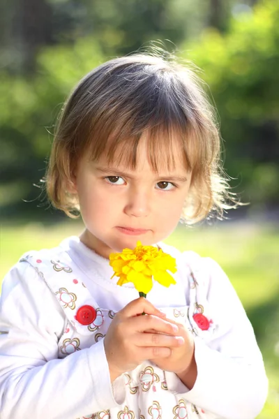 Little girl with yellow flower — Stock Photo, Image