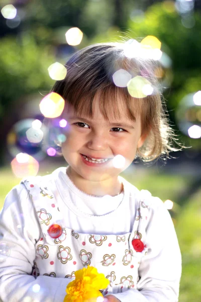 Mała dziewczynka z kwiat i baniek mydlanych — Zdjęcie stockowe