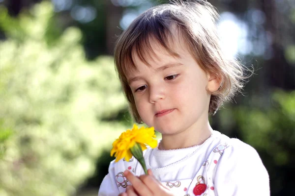 Leuk meisje met gele bloem — Stockfoto