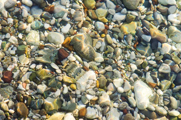 Pietricele de pe malul mării peste apă — Fotografie, imagine de stoc