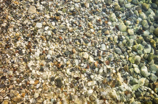 Pietricele de pe malul mării peste apă — Fotografie, imagine de stoc