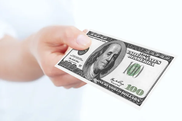 Sto dolarów banknotów przechowywany przez rękę nad białym — Zdjęcie stockowe