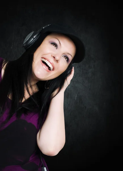 Улыбающаяся женщина с наушниками слушает музыку — стоковое фото