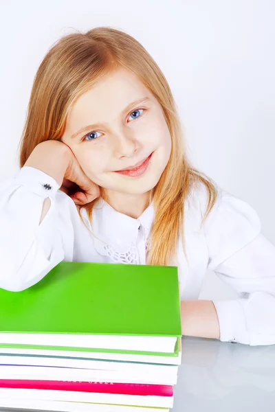 Маленькая улыбающаяся девочка с книгами — стоковое фото