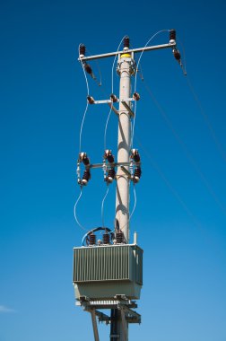 Electric pylon with isolators on blue sky background clipart