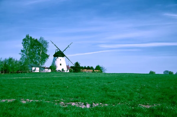 Weiße Windmühle auf dem grünen Acker — Stockfoto