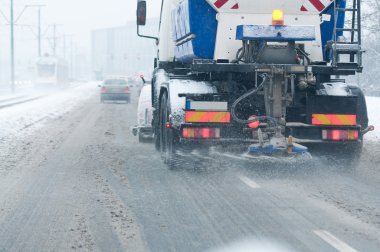 Snowblower in the street during the winter clipart