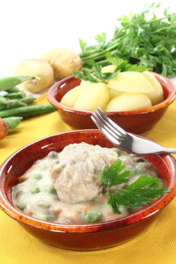 Fresh cooked meatballs in a white sauce with capers clipart