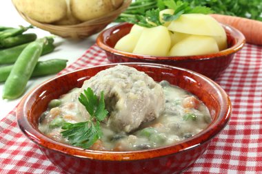 Cooked meatballs in a white sauce with capers and parsley clipart