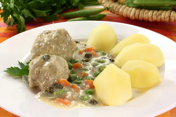 Cooked meatballs in a white sauce with capers — Stock Photo, Image