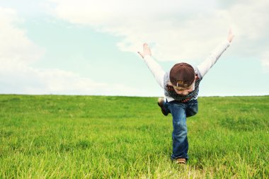 Young boy playing in a field clipart