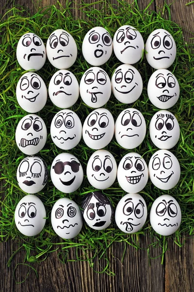 Huevos blancos y muchas caras divertidas — Foto de Stock
