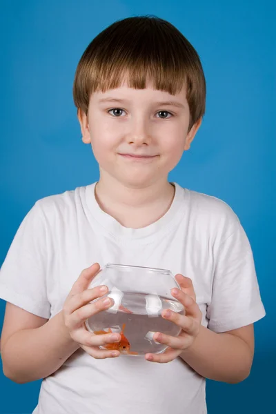 Boy holds a fishbowl with a goldfish — Stock Photo, Image