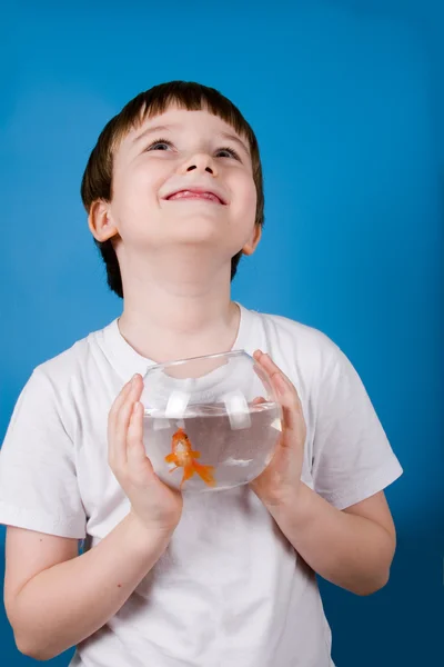 Garçon tient un bol à poisson avec un poisson rouge — Photo