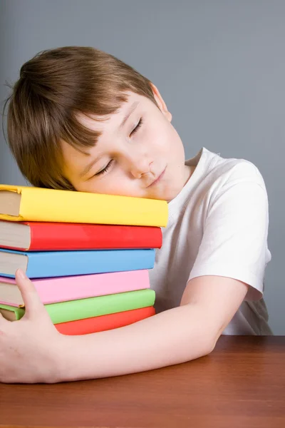 Fatigué garçon dort sur les livres — Photo
