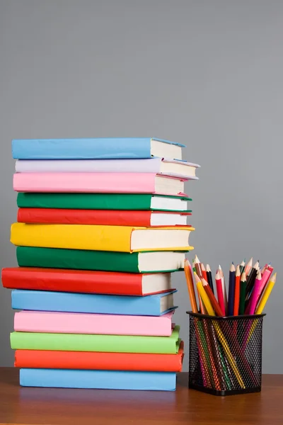 Crayons de couleur et une pile de livres — Photo