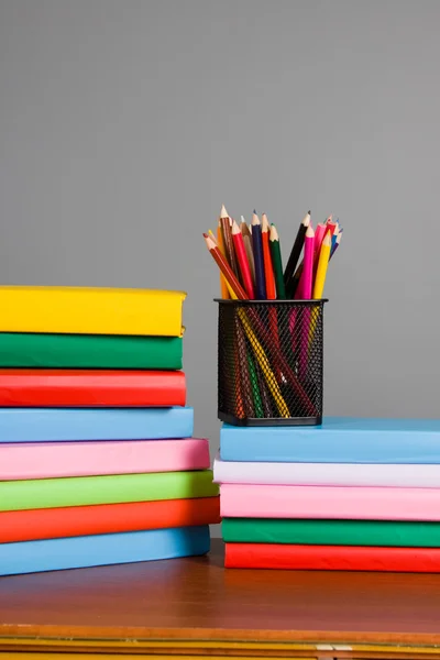 Цветные карандаши и стопка книг — стоковое фото