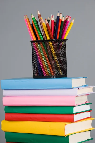 Кольорові олівці та стек книг — стокове фото