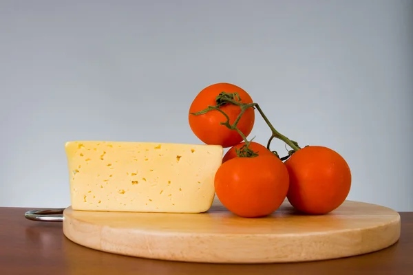 Yellow cheese with fresh tomatoes — Stock Photo, Image