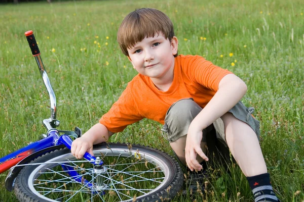 Boy sits next to the bike — Stock Photo, Image