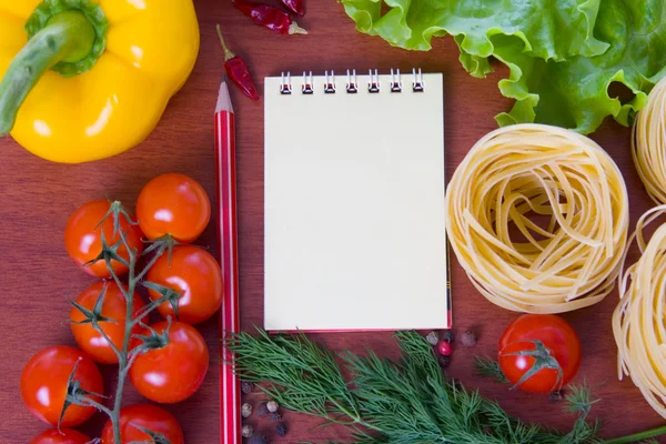 stock image Fresh vegetables,pasta and a notebook