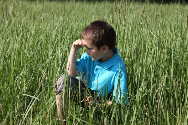 Chlapce, který seděl ve vysoké trávě — Stock fotografie