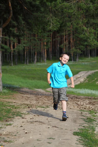 Happy boy runs near the forest — Stock Photo, Image
