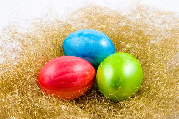 Tři velikonoční vejce v hnízdě zlatý — Stock fotografie