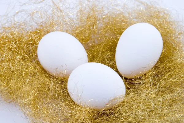 Üç beyaz yumurta golden yuva — Stok fotoğraf