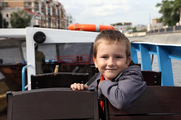 Boy riding excursion boat — Stock Photo, Image