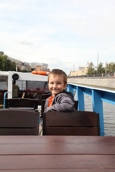 Boy riding excursion boat — Stock Photo, Image