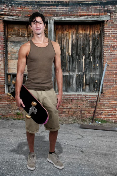 スケート ボードを持つ男 — ストック写真
