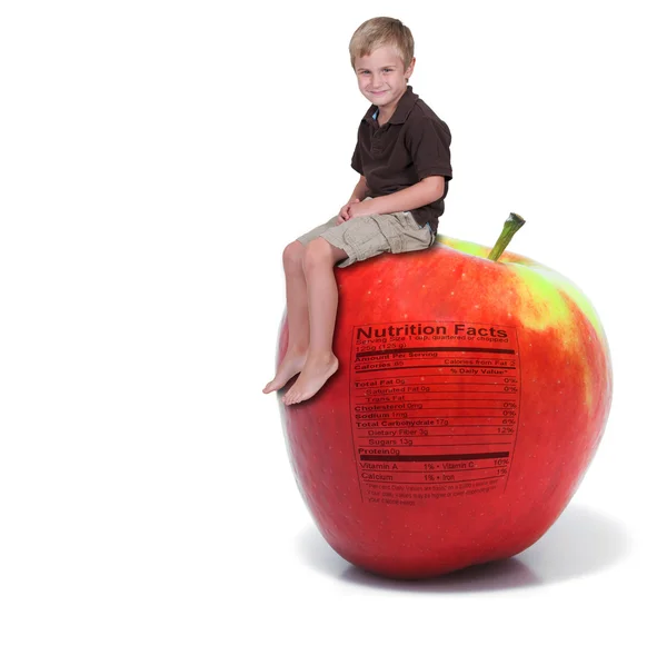 Kisfiú ül egy almát, a tápanyag-összetételre címkéje — Stock Fotó