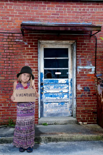 Маленькая девочка, держащая знак безработицы — стоковое фото