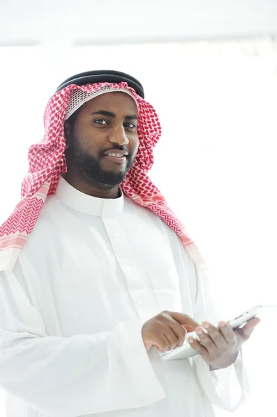 Moyen-Orient homme avec des vêtements de golfe en utilisant la tablette au bureau — Photo