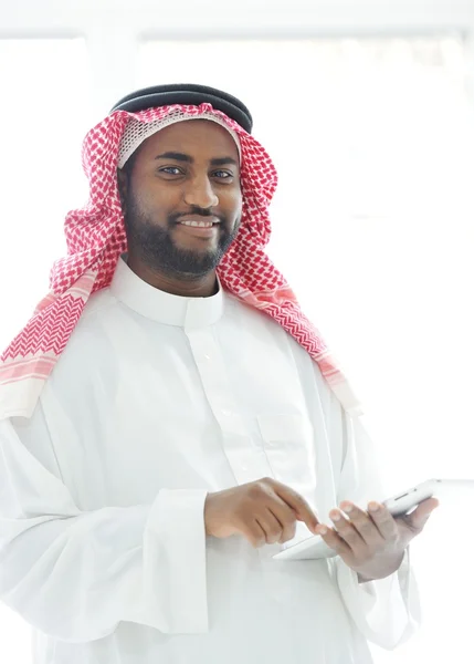 Μέσης Ανατολής άνθρωπος με ρούχα κόλπο χρησιμοποιώντας το δισκίο στο γραφείο — Φωτογραφία Αρχείου