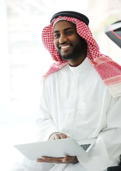Homem árabe preto trabalhando no laptop — Fotografia de Stock