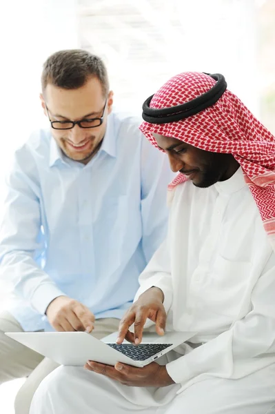 Árabe hombres negros y caucásicos trabajando juntos en el ordenador portátil — Foto de Stock