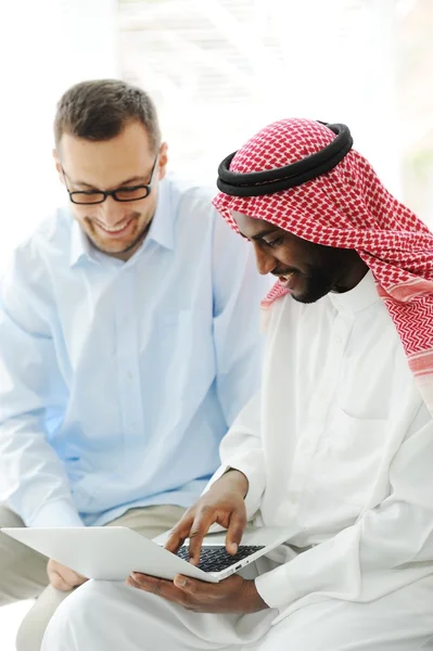 Árabe hombres negros y caucásicos trabajando juntos en el ordenador portátil —  Fotos de Stock
