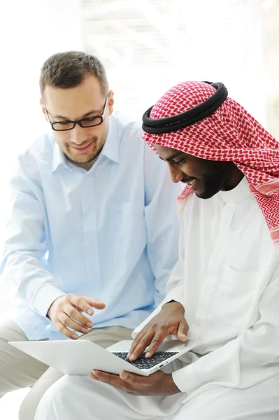 Arabe noir et caucasien hommes travaillant ensemble sur ordinateur portable — Photo
