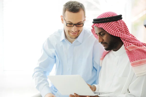 Arab fekete és kaukázusi férfiak dolgoznak együtt laptop — Stock Fotó