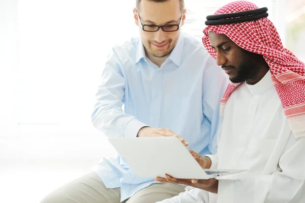 Arabic black and caucasian men working together on laptop — Stock Photo, Image