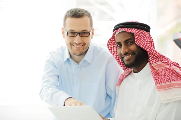 Άραβες μαύροι και Καυκάσιοι άνδρες που εργάζονται μαζί σε φορητό υπολογιστή — Φωτογραφία Αρχείου