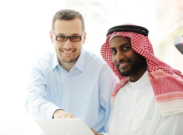 Arab fekete és kaukázusi férfiak dolgoznak együtt laptop — Stock Fotó