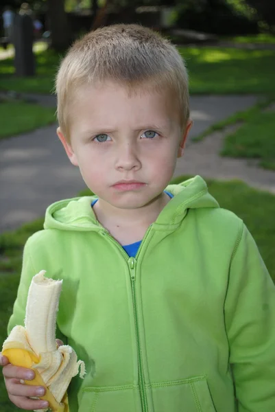 Kis fiú étkezési banán — Stock Fotó