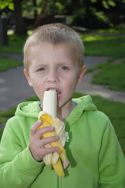 Menino comendo banana — Fotografia de Stock