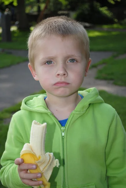 Мальчик ест банан Лицензионные Стоковые Фото
